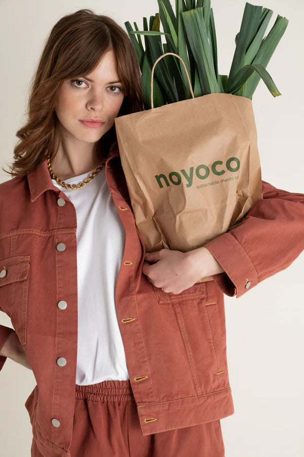 mannequin femme portant une veste orange et un sac noyoco