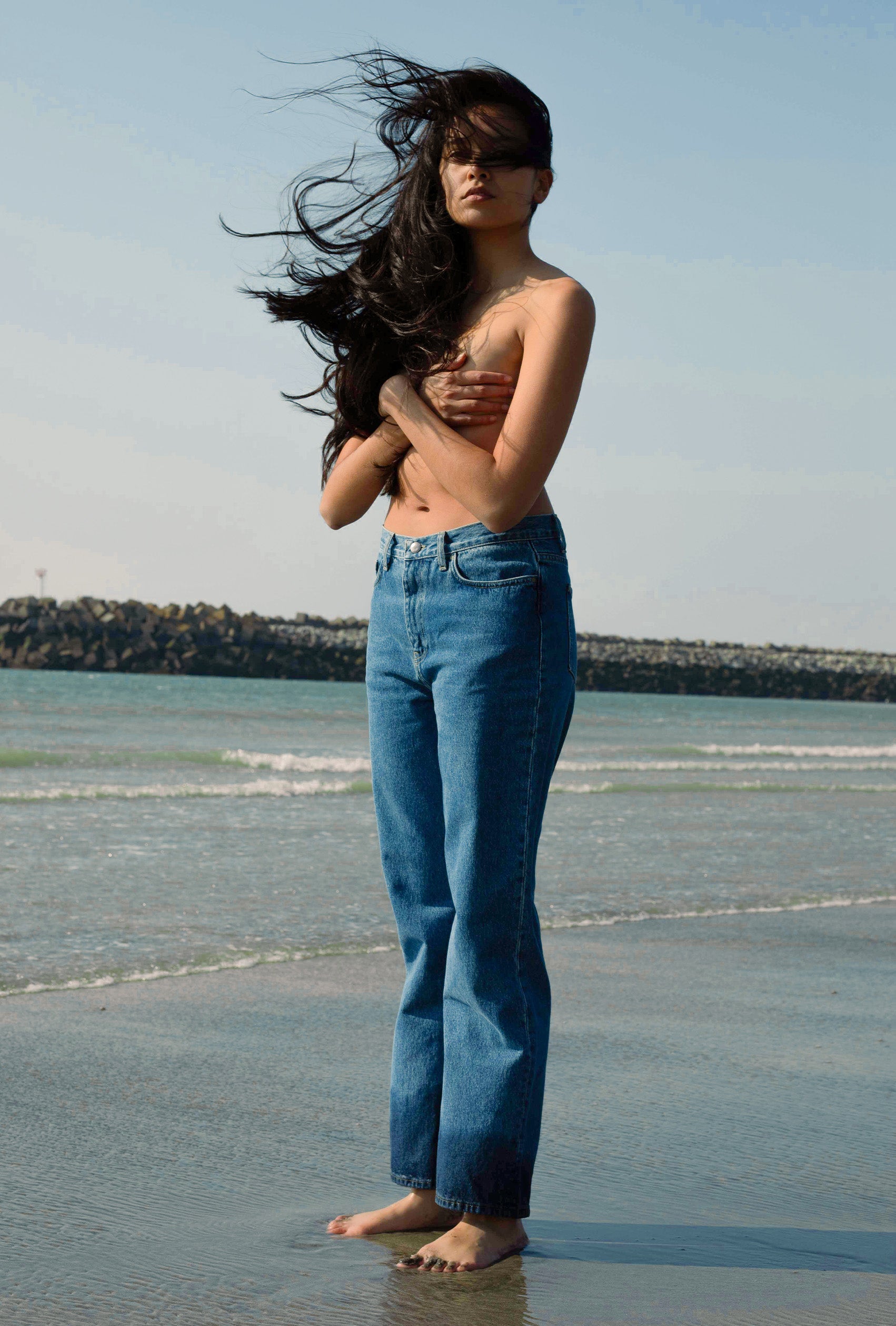 femme poitrine nue portant un jean à la plage