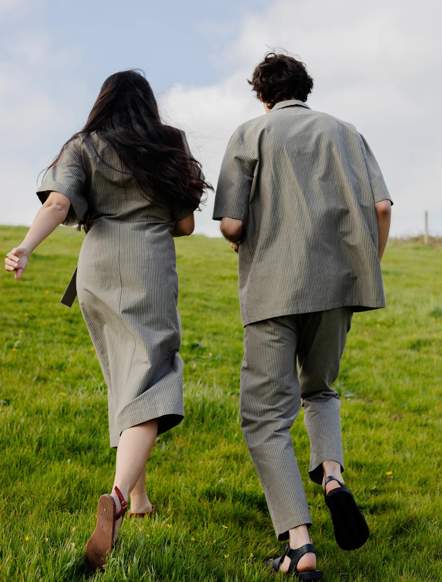 couple portant une tenue complémentaire gris courant des les champs d'herbe verte
