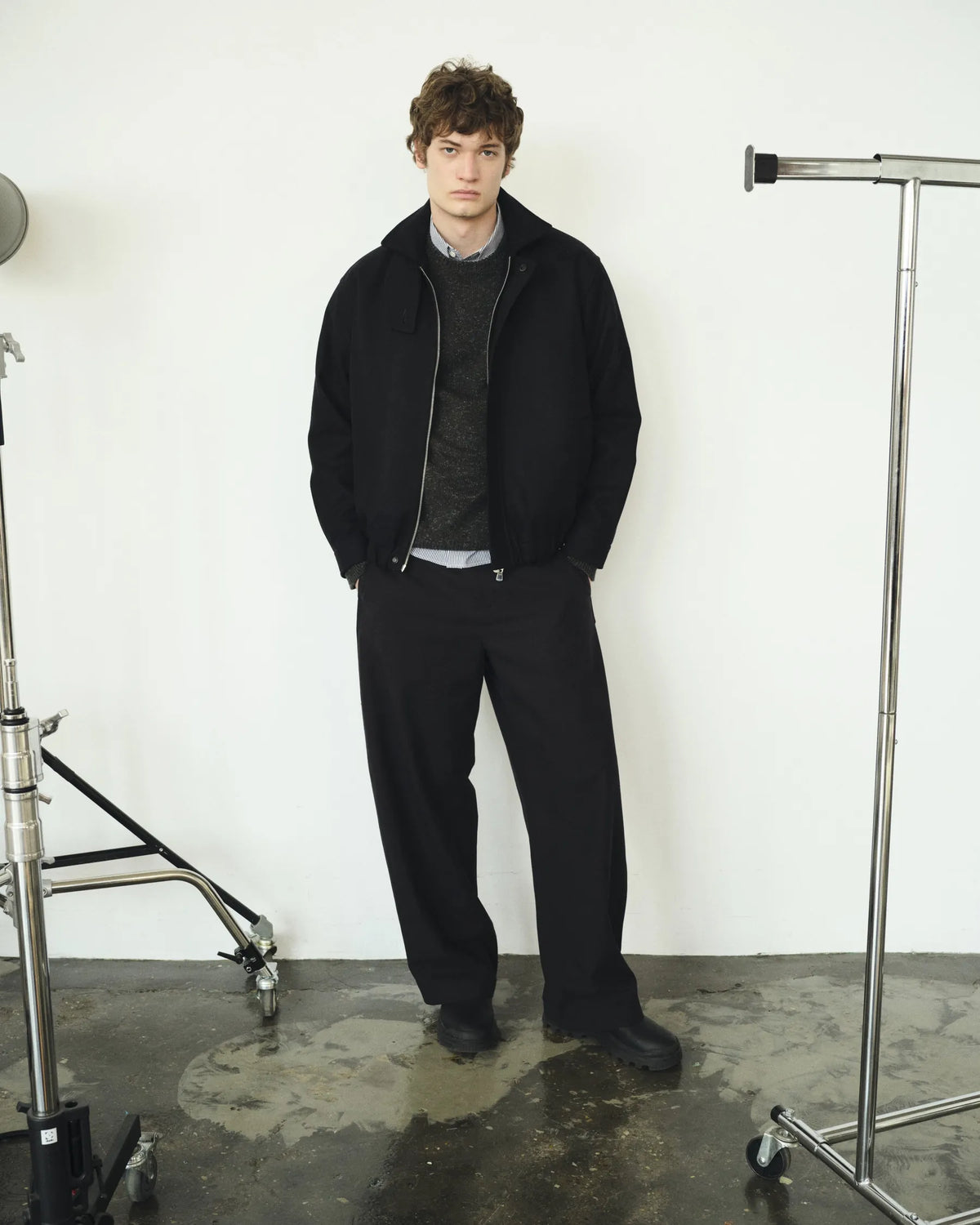 Silhouette homme noire et anthracite parmi les pieds de studio