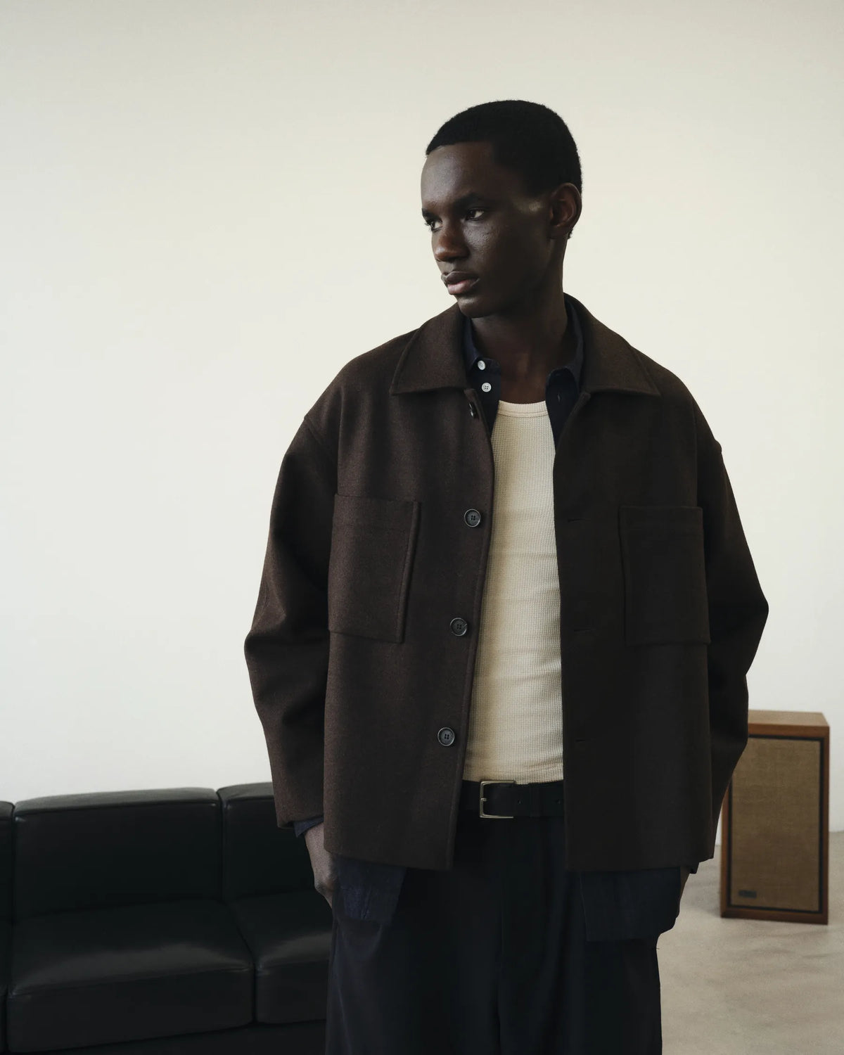 Silhouette homme en veste brune près du canapé