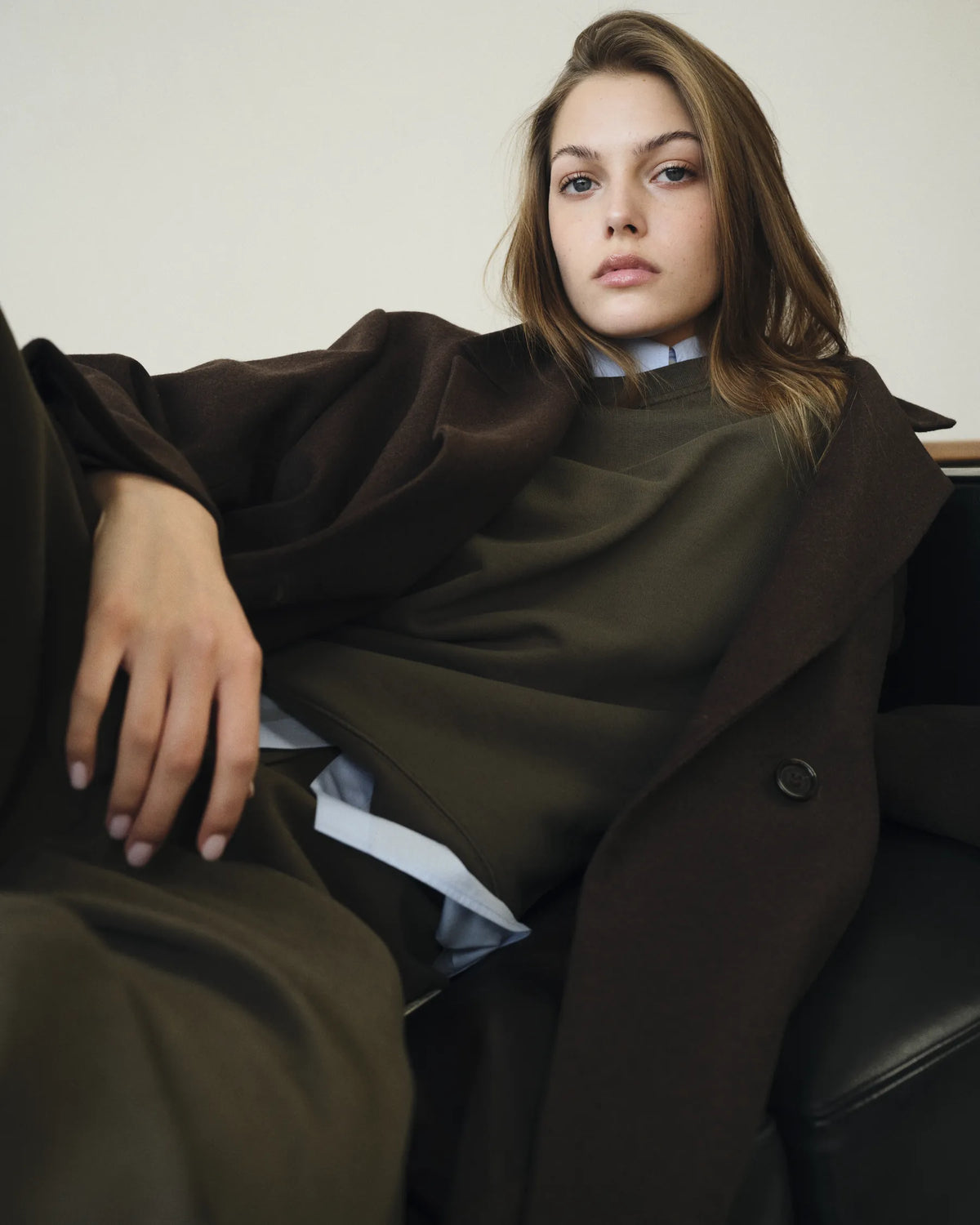 Portrait femme allongée en blazer brun et maille olive
