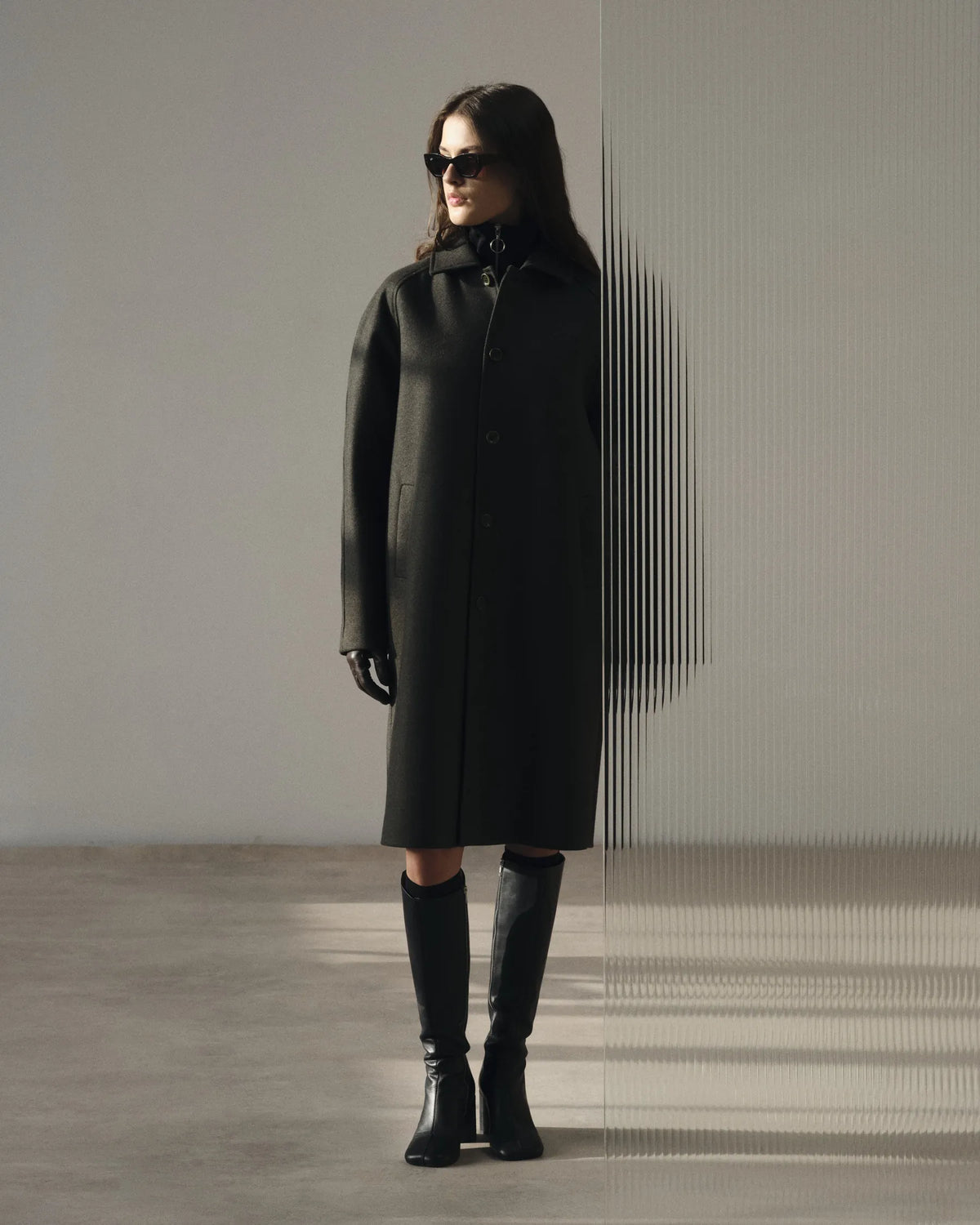 Silhouette femme en long manteau anthracite et bottes