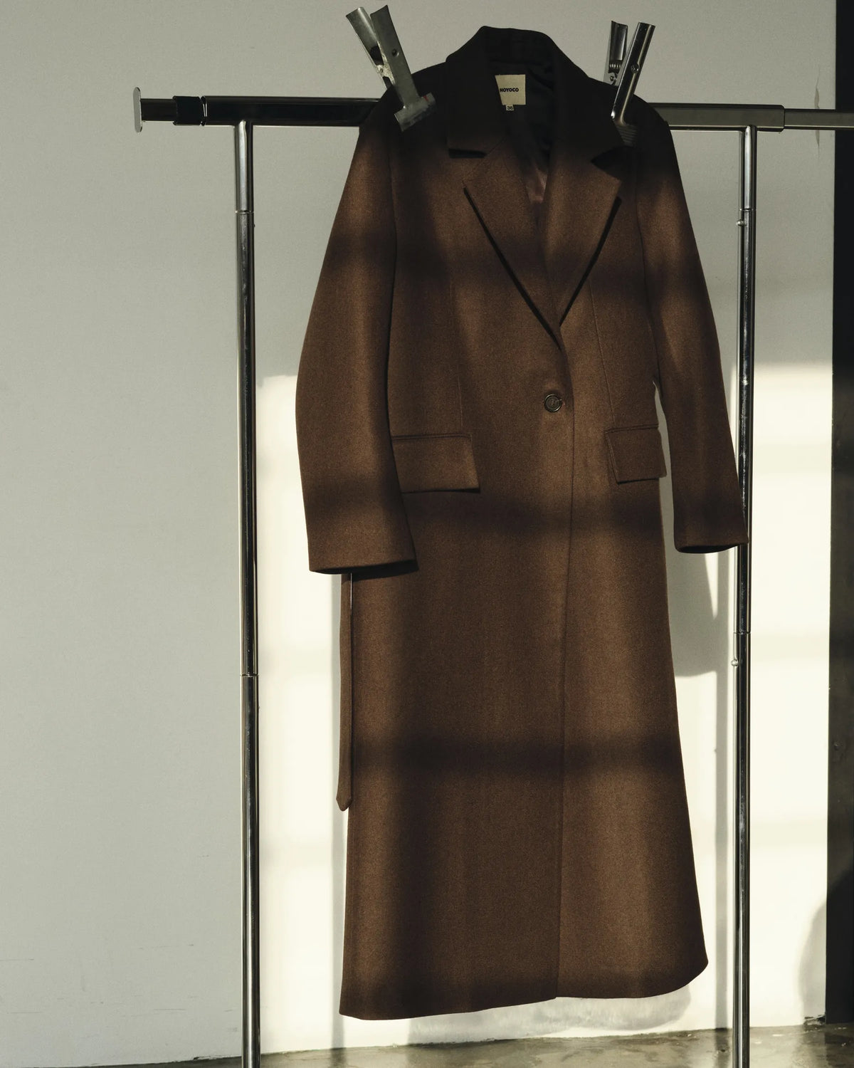 Manteau brun suspendu sur un portant dans le studio