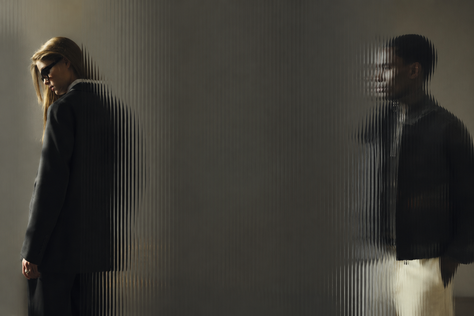 NOYOCO AW26 campaign, two figures behind ribbed glass